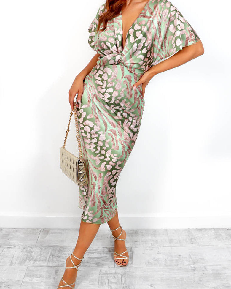 Woman wearing a green and white patterned dress with a white background