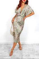 Woman wearing a green and white patterned dress with a white background